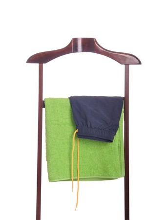 man beach clothing on a wooden hanger with green towel and blue swimsuit (isolated on white background)の写真素材