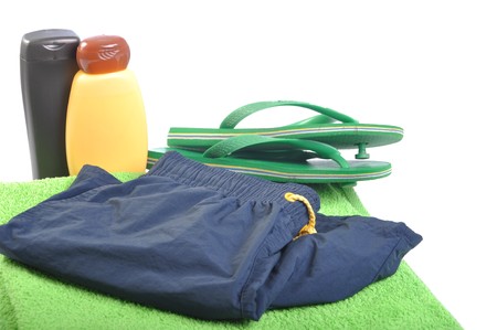 beach concept with sun lotion, flip flops, towel and swimsuit (isolated on white background)の写真素材