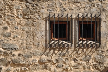 ancient windows of a medieval building with barsの写真素材