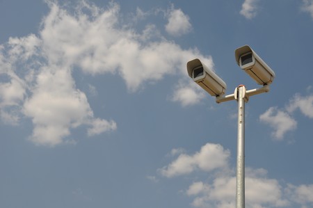 video surveillance cameras against blue sky backgroundの写真素材