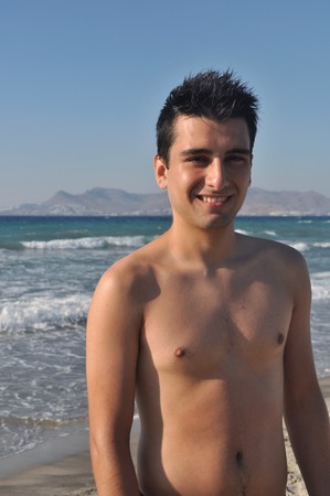 smiling young man at Kos beach in Greece (blue sky)の写真素材