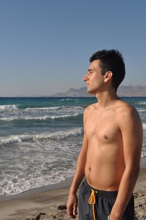 handsome young man getting suntan at Kos beach in Greece (blue sky)の写真素材