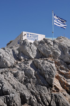 gorgeous greek house and flag on the stones of Pserimos islandの写真素材