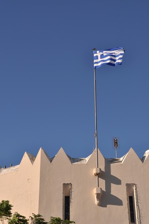 national flag of Greece on Kos town building (blue sky background)の写真素材