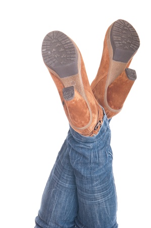 woman with legs up in jeans wearing leather fashion boots (isolated on white background)の写真素材