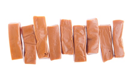 row of caramels pieces isolated on white backgroundの写真素材