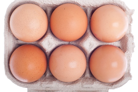 detail of six eggs in a carton box isolated on white backgroundの写真素材