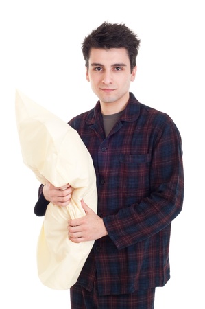 happy young man in pajamas holding pillow isolated on white backgroundの写真素材