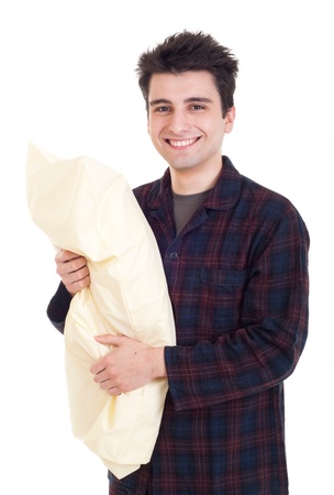 smiling young man in pajamas holding pillow isolated on white backgroundの写真素材
