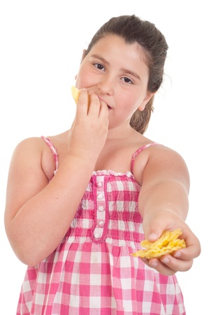 cute little girl eating chips and offering some too (isolated on white background)の写真素材