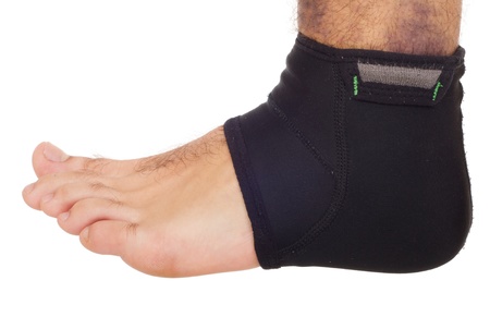 young male with ankle support to treat a sprain (isolated on white background)の写真素材