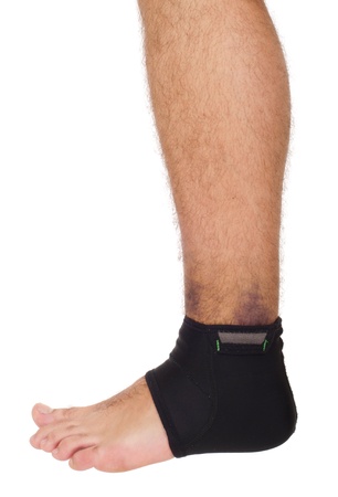 young male with ankle support to treat a sprain (isolated on white background)の写真素材