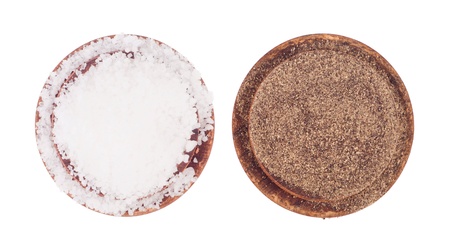 salt and pepper condiments on vintage wooden plates (isolated on white background)の写真素材