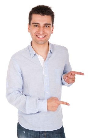 smiling young casual man pointing at something (isolated on white background)の写真素材
