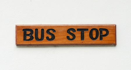 wooden bus stop sign on a white wallの写真素材