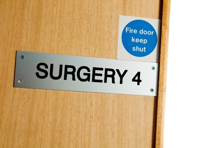 surgery sign at a wooden door (copy-space available, isolated on white)の写真素材