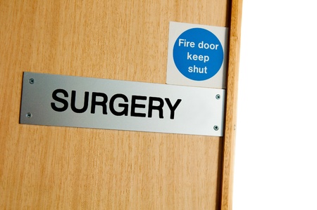 surgery sign at a wooden door (copy-space available, isolated on white)の写真素材