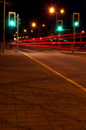 night traffic on a urban road with tail lights (green traffic lights scene, long exposure)の写真素材