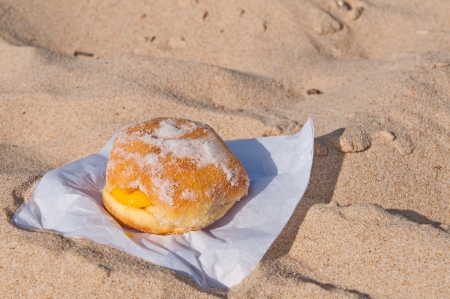 berliner ball on a sandy beach in Algarve, Portugal  traditionally sold during all summer の写真素材