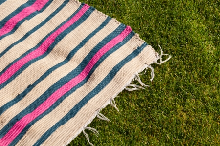 colorful picnic blanket on the grass fieldの写真素材
