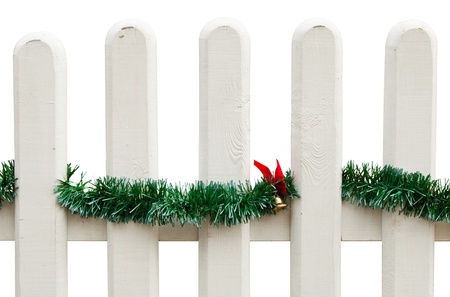 decorated Christmas fence with green tinsel and golden bell with bow (isolated on white background)の写真素材