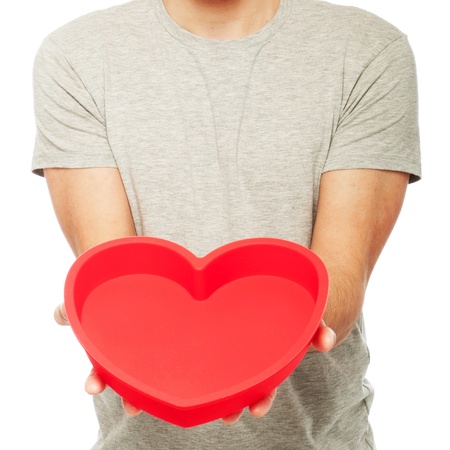 man holding a red heart (isolated on white background)の写真素材