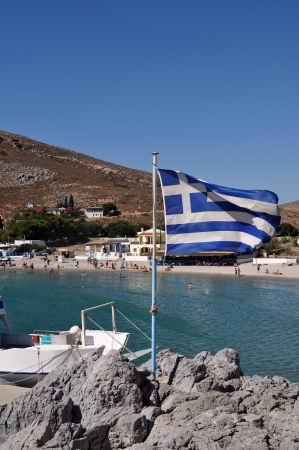 beautiful bay of Pserimos island with Greece flagの写真素材