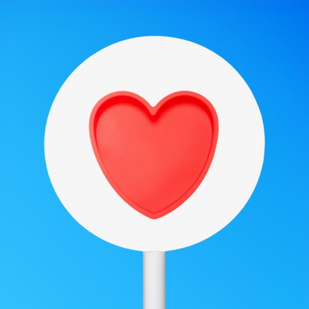 conceptual picture of a sign with a red heart against a blue sky (sign cleaned on grey)の写真素材