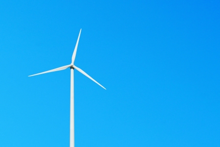 white wind turbine against a vibrant blue sky (copy-space for your design)の写真素材