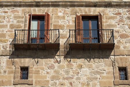 Old iron and wood balconies on a stone wallの写真素材