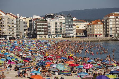 SANXENXO, SPAIN - AUGUST 12, 2019: Silgar beach in Sanxenxo full of bathers on a summer day. One of the most important and well-known summer places in Galiciaのeditorial素材