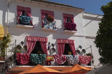 MARBELLA, SPAIN - JUNE 21, 2019: Picturesque balconies typical of Marbella, Spain. Balconies of the Plaza de los Naranjos adorned with curtains, fabrics and colorful flowersのeditorial素材
