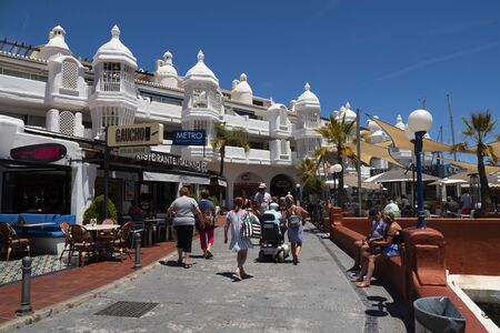 Benalmadena, SPAIN - JUNE 19, 2019: Malecon of the port of Benalmadena. View of the boardwalk with walkers and the balconies of the harbor housesのeditorial素材