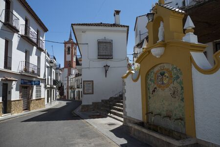 CORTES DE LA FRONTERA, SPAIN - JUNE 20, 2019: View of Cortes de la Frontera, one of the villages of the Sierra de Grazalema Natural Park. A fountain first and, in the background, the bell tower of the churchのeditorial素材