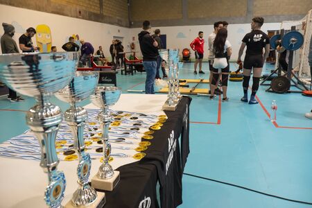 TEIXEIRO, SPAIN - JANUARY 15, 2020: Trophies and competitors. Table with trophies of the Galician powerlifting championshipのeditorial素材