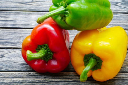 Sweet red green yellow bell pepper on wooden table backgroundの写真素材