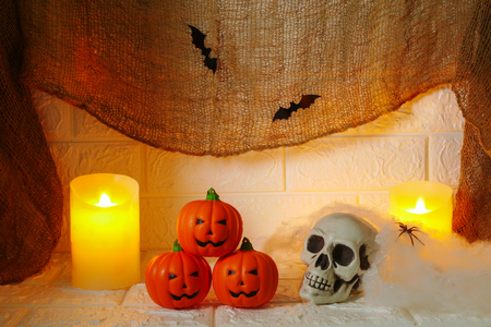 Halloween decoration pumpkin, candles and horror skull on wall backgroundの写真素材