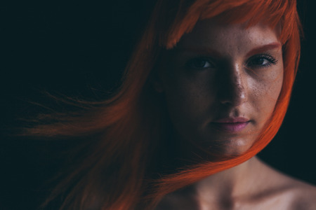 Young woman in white dress in dark forestの写真素材