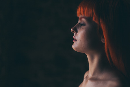 Young woman in white dress in dark forestの写真素材