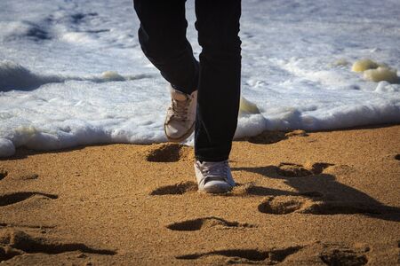 Photo of a man walking on the beach, nazare, portugalの写真素材