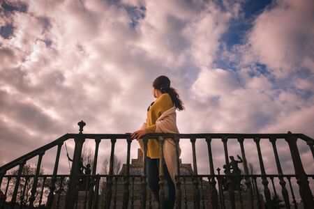 Photo of a beautiful woman looking to the dramatic skyの写真素材