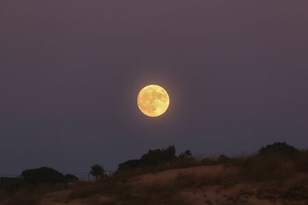 A beautiful full moon, over the guincho beach, in cascais, portugalの写真素材