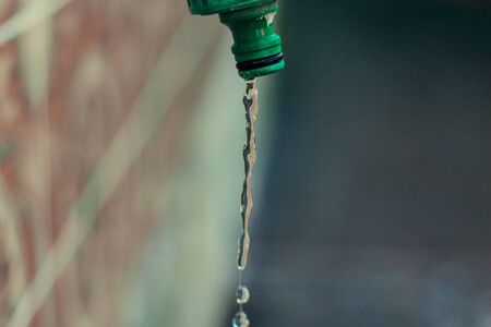 Water dripping from a faucet in the yardの写真素材