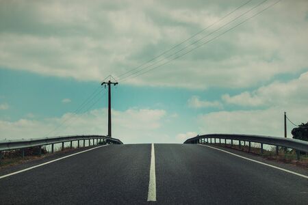 A road under blue sky with clouds, Portugalの写真素材