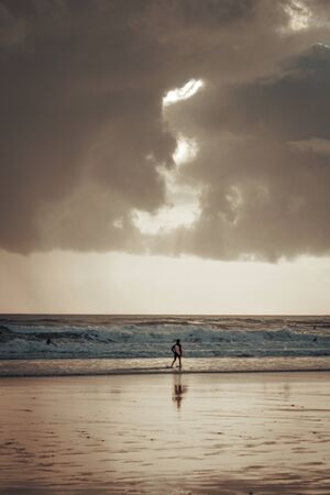A surfer entering the sea, Caravelos beach, Portugalの写真素材