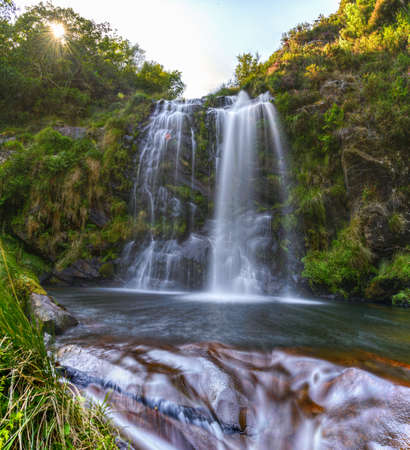 Water flows over the rocks under a waterfall in Muras, Galiciaの写真素材