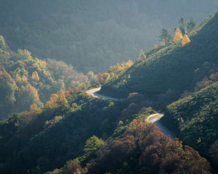 Rural road winds its way through the mid-slope between the mountains of the Couel Mountain Range GEopark in Autumnの写真素材