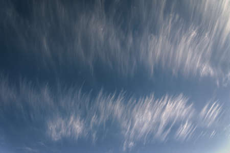 Delicate cirrostratus cloud filaments under a blue sky