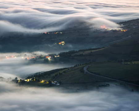 Banks of morning fog cover some valley villages in the mountains of Lugo Galicia