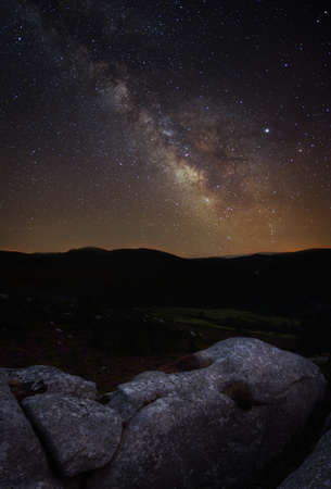 Night landscape with the Milky Way over a rock shaped like a human head in the Xistral Mountain...